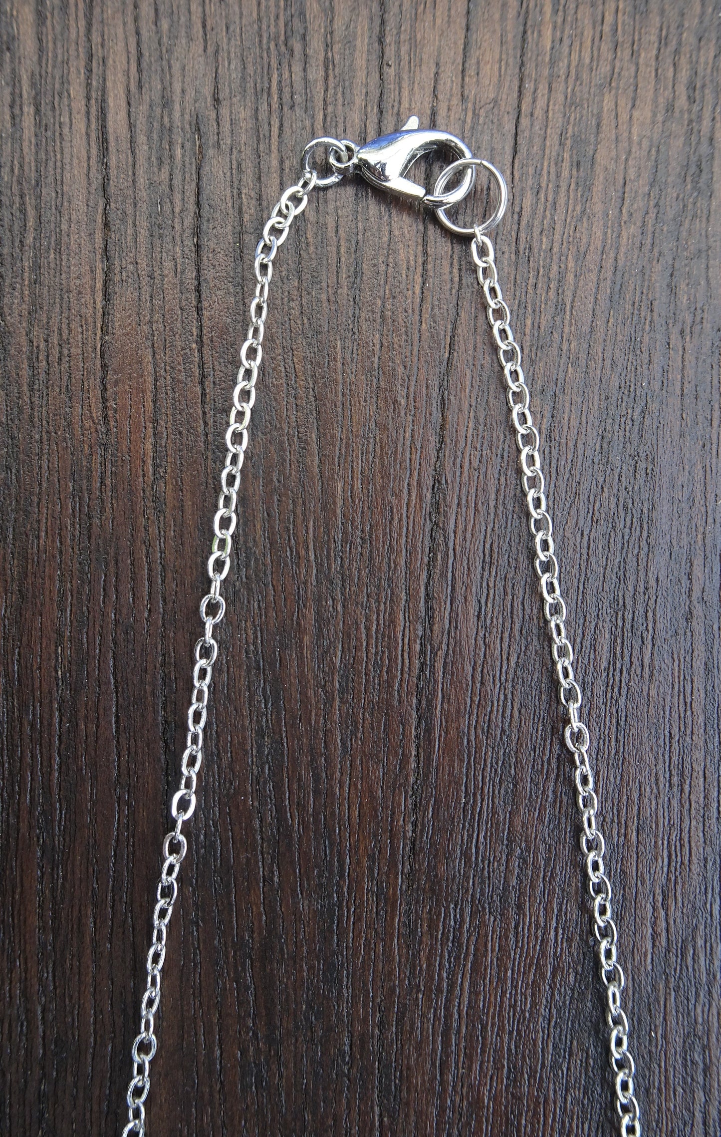 Collier chaîne argentée avec perle naturelle beige mouchetée de noir posée sur étrier - CO003/B