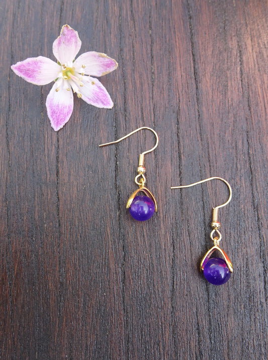 Boucles d'oreilles perle naturelle violette 7 mm posée sur un étrier doré - BO141